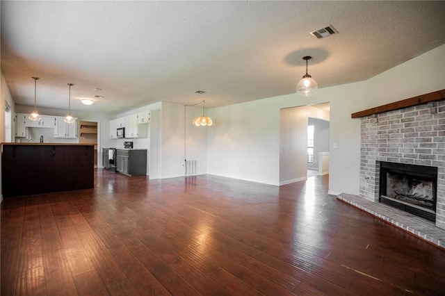 707 Turtle Creek Dr, Rogers, AR 72756 - unfurnished living room featuring a fireplace, dark wood-type flooring, and a textured ceiling