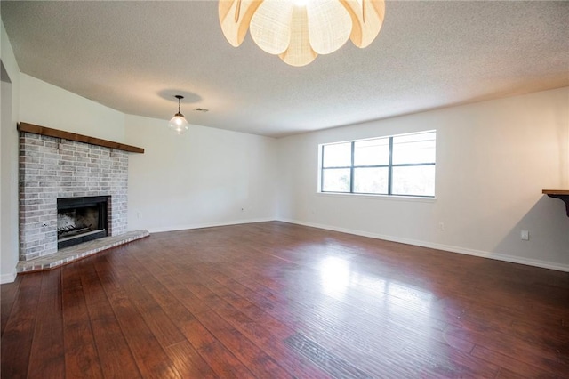 707 Turtle Creek Dr, Rogers, AR 72756 - unfurnished living room with a textured ceiling, dark wood-style flooring, and a brick fireplace