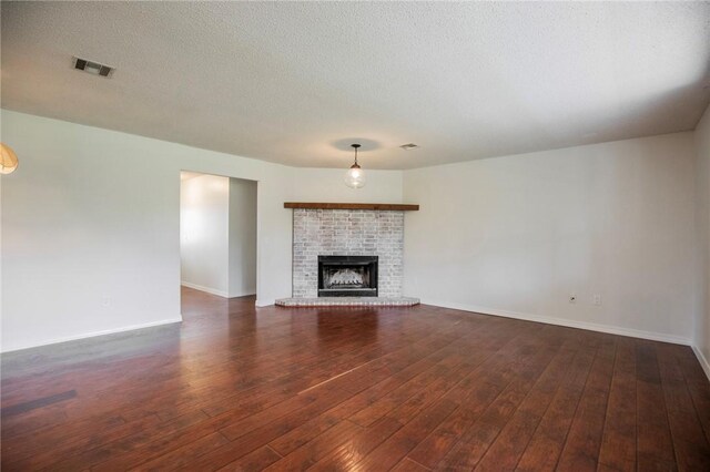 707 Turtle Creek Dr, Rogers, AR 72756 - unfurnished living room with dark wood-style flooring, a textured ceiling, and a brick fireplace
