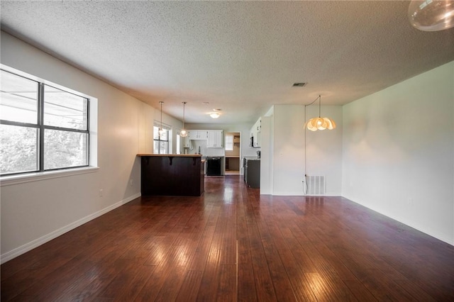 707 Turtle Creek Dr, Rogers, AR 72756 - unfurnished living room featuring dark wood-style flooring, a textured ceiling, and a chandelier
