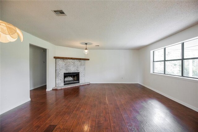 707 Turtle Creek Dr, Rogers, AR 72756 - unfurnished living room featuring dark wood-type flooring, a fireplace, and a textured ceiling