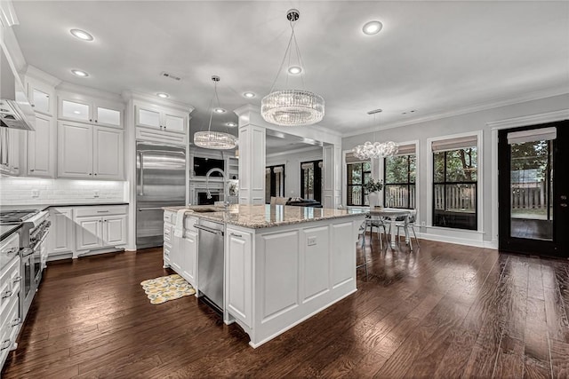 601 Chattin Cir, Bentonville, AR 72713 - kitchen with high quality appliances, a chandelier, white cabinetry, dark wood-style floors, and ornamental molding