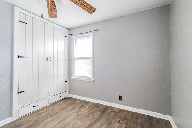 845 S Wright St, Siloam Springs, AR 72761 - unfurnished bedroom with wood finished floors and ceiling fan
