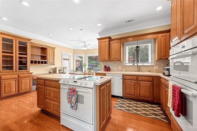 8270 Titleist Cir, Rogers, AR 72756 - kitchen featuring white appliances, light countertops, a kitchen island, ornamental molding, and light wood-style floors