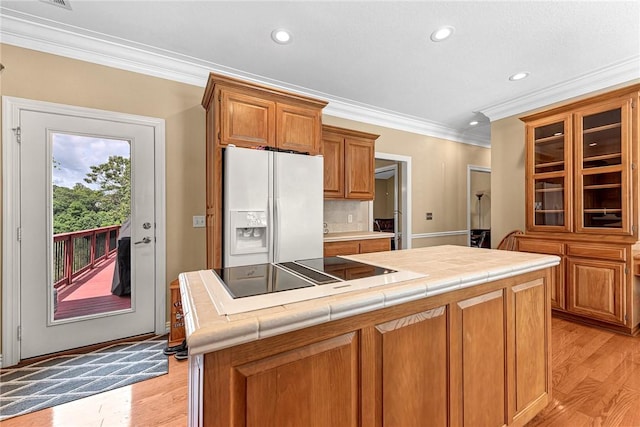 8270 Titleist Cir, Rogers, AR 72756 - kitchen with white refrigerator with ice dispenser, black electric cooktop, tile counters, ornamental molding, and recessed lighting