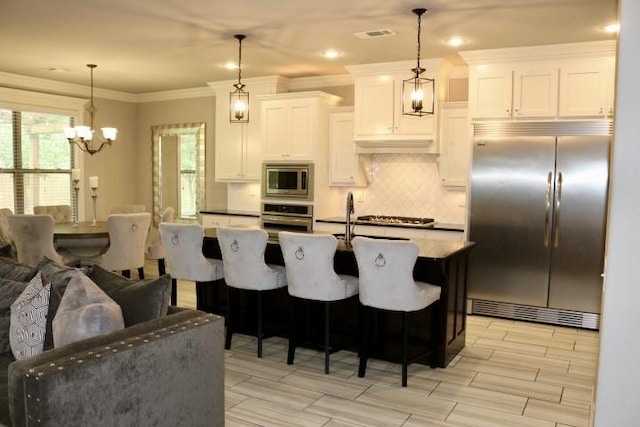 1730 Helen Ln, Bentonville, AR 72713 - kitchen with built in appliances, tasteful backsplash, a chandelier, white cabinets, and crown molding