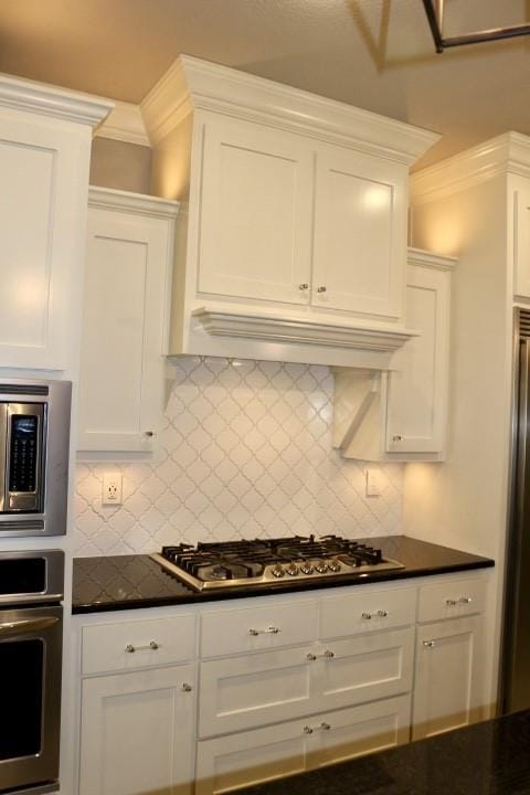 1730 Helen Ln, Bentonville, AR 72713 - kitchen featuring stainless steel appliances, dark countertops, white cabinetry, and ornamental molding