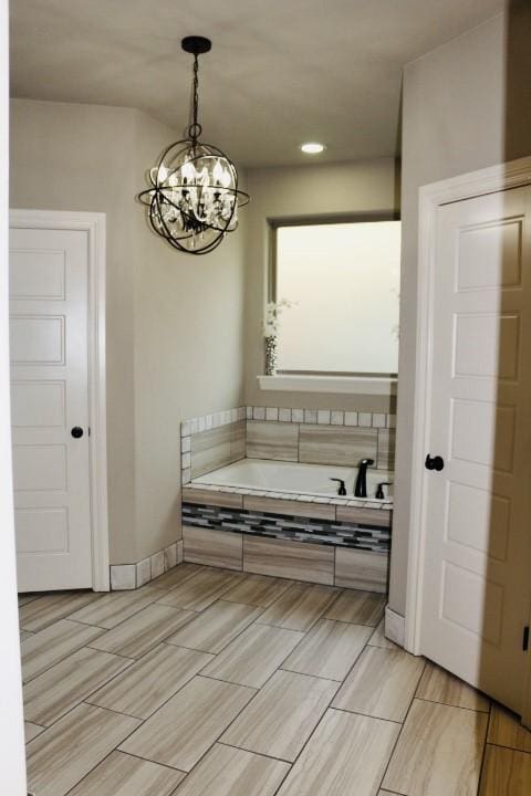 1730 Helen Ln, Bentonville, AR 72713 - bathroom featuring a chandelier, a bath, wood finish floors, and recessed lighting