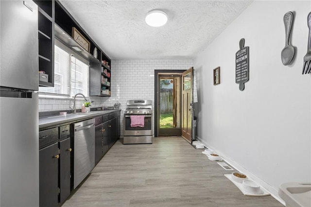 224 N Allen St, Harrison, AR 72601 - kitchen featuring appliances with stainless steel finishes, open shelves, a textured ceiling, light wood-type flooring, and dark countertops