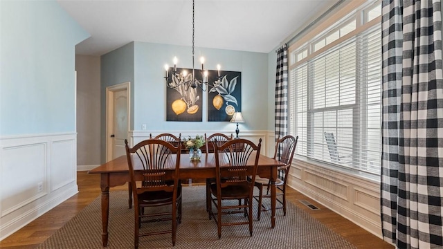 4903 S Inglewood Rd, Rogers, AR 72758 - dining space featuring a chandelier, a decorative wall, wood finished floors, healthy amount of natural light, and a wainscoted wall