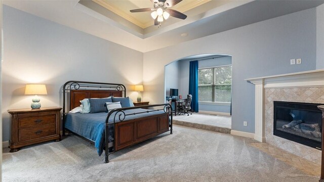 4903 S Inglewood Rd, Rogers, AR 72758 - bedroom with light colored carpet, a raised ceiling, an office area, arched walkways, and a tile fireplace