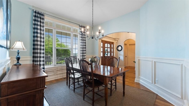 4903 S Inglewood Rd, Rogers, AR 72758 - dining space featuring arched walkways, wainscoting, a decorative wall, dark wood-style floors, and a chandelier