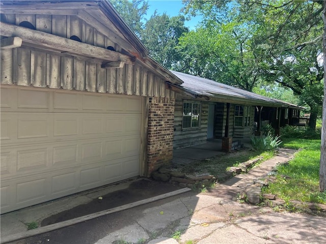 1445 Viewpoint Dr, Fayetteville, AR 72701 - view of home's exterior featuring brick siding, an attached garage, and asphalt driveway
