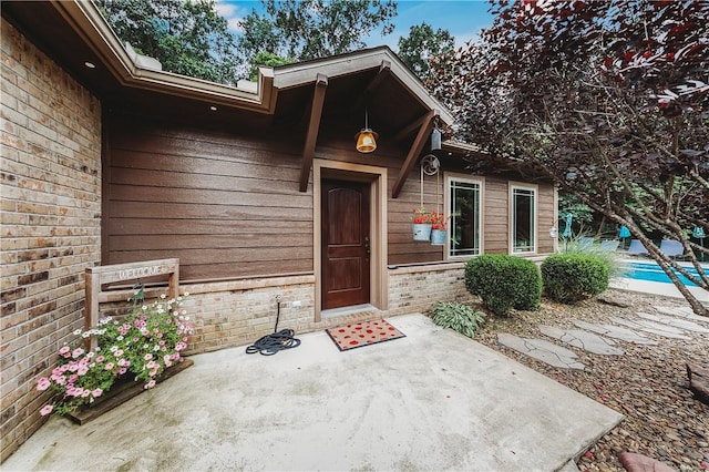 19123 Nokes Farm Rd, Siloam Springs, AR 72761 - entrance to property featuring brick siding, a patio area, and an outdoor pool