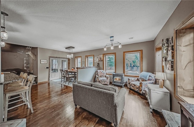19123 Nokes Farm Rd, Siloam Springs, AR 72761 - living room featuring a wood stove, a textured ceiling, and dark wood-style floors
