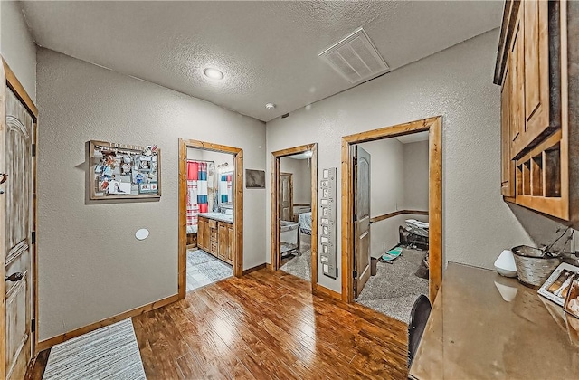 19123 Nokes Farm Rd, Siloam Springs, AR 72761 - hall with a textured wall, a textured ceiling, and light wood-style flooring