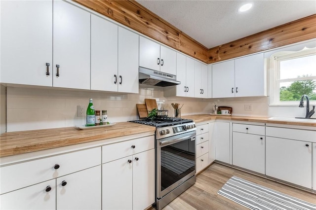 1916 S 12th St, Rogers, AR 72758 - kitchen featuring stainless steel gas stove, under cabinet range hood, tasteful backsplash, white cabinets, and a textured ceiling