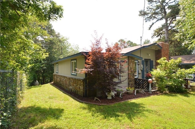 8096 Magnolia Ln, Rogers, AR 72756 - view of side of property featuring stone siding, a yard, and a chimney