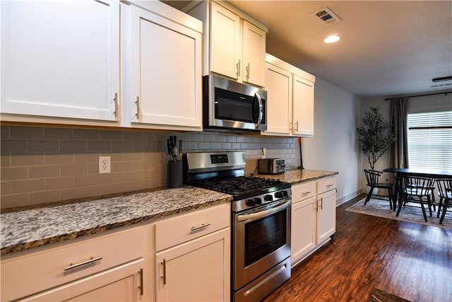 2756 Cassidy Ave, Springdale, AR 72764 - kitchen featuring appliances with stainless steel finishes, dark wood-style flooring, tasteful backsplash, and light stone counters