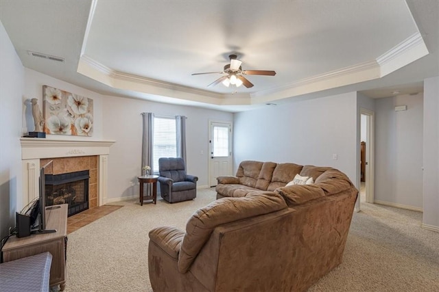 3405 SW Picasso Blvd, Bentonville, AR 72712 - living room with a tray ceiling, ornamental molding, light colored carpet, ceiling fan, and a tiled fireplace