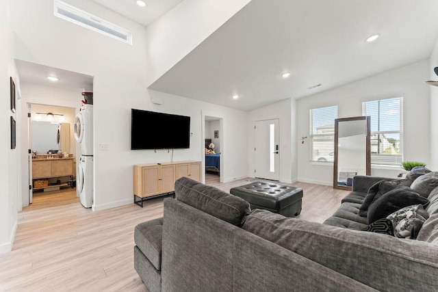 671 St Charles Pl, Bentonville, AR 72713 - living room featuring estacked washer and dryer, light wood-style floors, recessed lighting, and vaulted ceiling