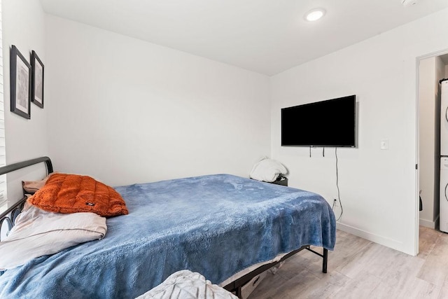 671 St Charles Pl, Bentonville, AR 72713 - bedroom with estacked washer and dryer and light wood-style floors