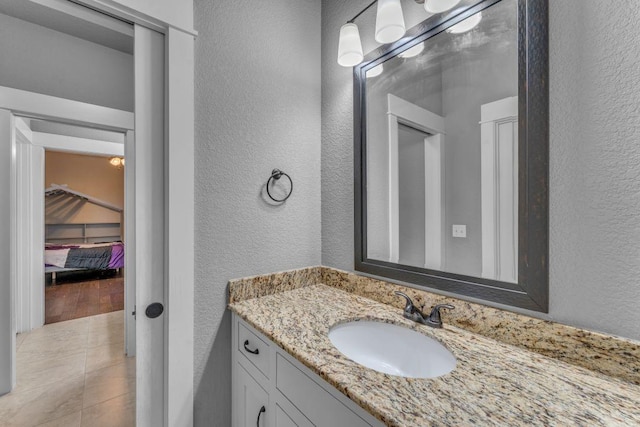 1315 W Magnolia St, Rogers, AR 72758 - bathroom featuring a textured wall, vanity, and tile patterned floors