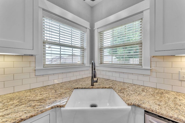 1315 W Magnolia St, Rogers, AR 72758 - kitchen view of tasteful backsplash, dishwashing machine, light stone counters, and white cabinets