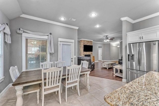 1315 W Magnolia St, Rogers, AR 72758 - dining space featuring ornamental molding, ceiling fan, a stone fireplace, recessed lighting, and light tile patterned floors