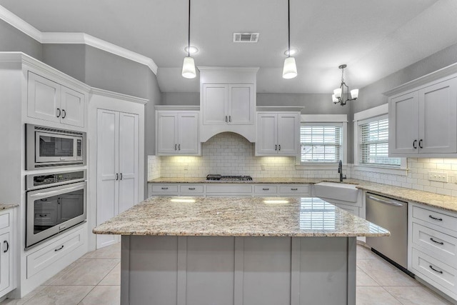 1315 W Magnolia St, Rogers, AR 72758 - kitchen with stainless steel appliances, a chandelier, decorative backsplash, and white cabinets