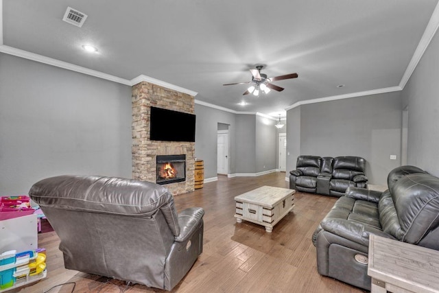 1315 W Magnolia St, Rogers, AR 72758 - living room featuring a ceiling fan, ornamental molding, wood finished floors, and a stone fireplace