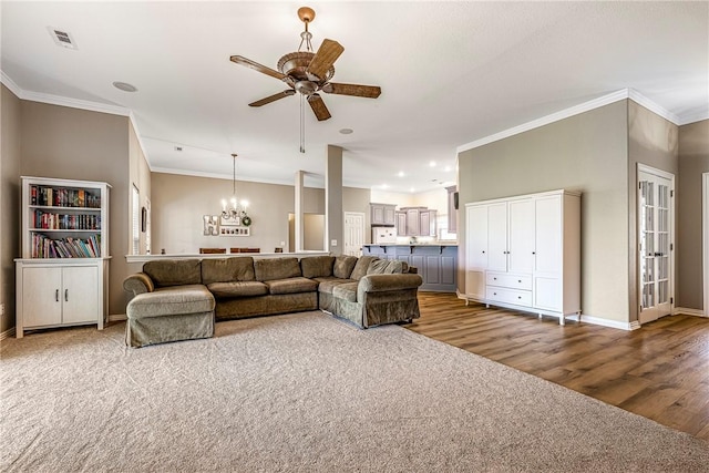 372 Niagara St, Elm Springs, AR 72762 - living room featuring a ceiling fan, wood finished floors, crown molding, a chandelier, and carpet