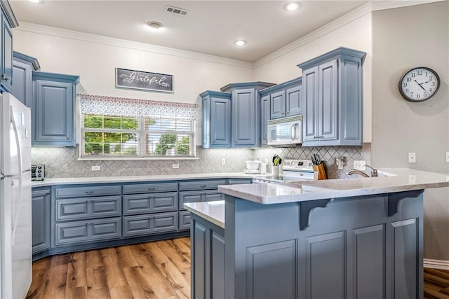 372 Niagara St, Elm Springs, AR 72762 - kitchen featuring white appliances, a peninsula, dark wood-style flooring, blue cabinetry, and ornamental molding