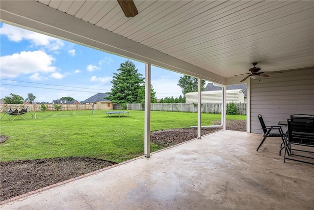 372 Niagara St, Elm Springs, AR 72762 - fenced backyard with a trampoline, a ceiling fan, and a patio area