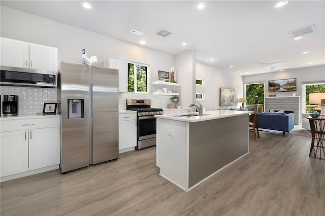 239 N Fletcher Ave, Fayetteville, AR 72701 - kitchen featuring stainless steel appliances, backsplash, white cabinetry, light wood-style floors, and recessed lighting