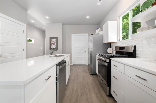 239 N Fletcher Ave, Fayetteville, AR 72701 - kitchen with appliances with stainless steel finishes, white cabinets, tasteful backsplash, wood finished floors, and light countertops