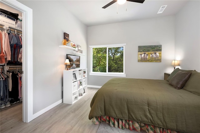 239 N Fletcher Ave, Fayetteville, AR 72701 - bedroom with a walk in closet, a closet, wood finished floors, and a ceiling fan