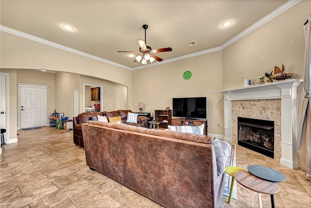 4300 Limestone Ave, Bentonville, AR 72712 - living room with a ceiling fan, a tiled fireplace, ornamental molding, arched walkways, and recessed lighting