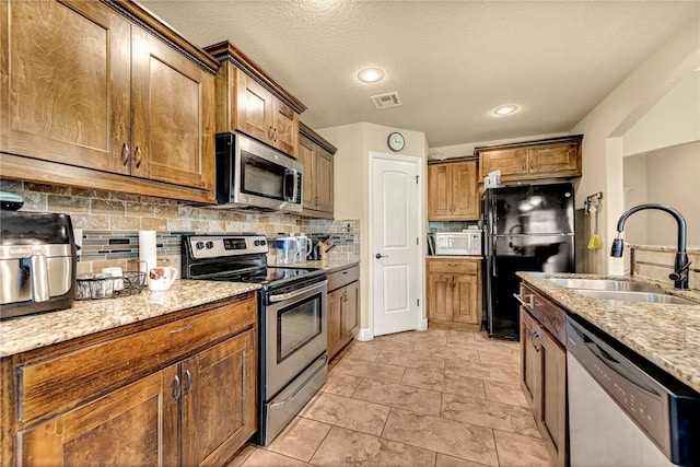 4300 Limestone Ave, Bentonville, AR 72712 - kitchen featuring stainless steel appliances, backsplash, and light stone countertops