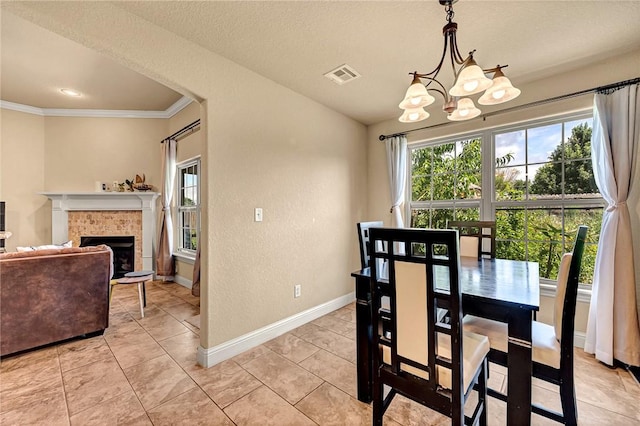4300 Limestone Ave, Bentonville, AR 72712 - dining space with ornamental molding, a chandelier, a tiled fireplace, light tile patterned floors, and a textured wall