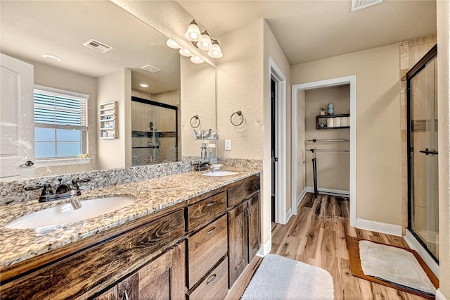 4300 Limestone Ave, Bentonville, AR 72712 - bathroom with a stall shower, double vanity, and wood finished floors