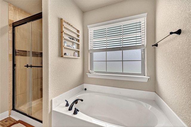 4300 Limestone Ave, Bentonville, AR 72712 - bathroom featuring a textured wall, a garden tub, and a shower stall