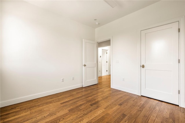 302 NW 5th St, Bentonville, AR 72712 - unfurnished bedroom with wood finished floors and baseboards