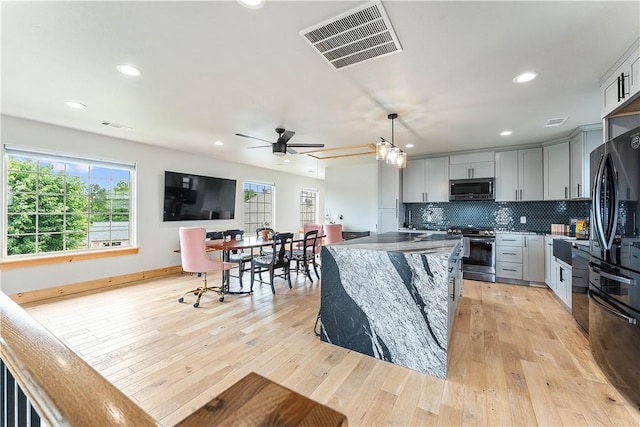 11 Darian Dr, Bentonville, AR 72712 - kitchen featuring stainless steel appliances, light wood-type flooring, a ceiling fan, a center island, and gray cabinetry