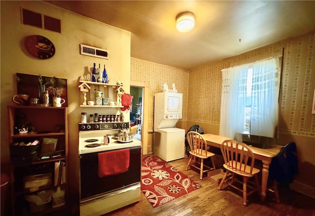 1 Ridgeway Ave, Eureka Springs, AR 72632 - dining room with stacked washing machine and dryer, wallpapered walls, and wood finished floors