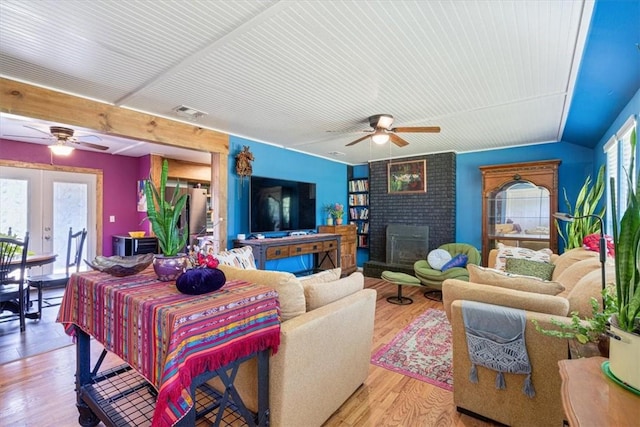 20490 Rocky Branch Rd, Rogers, AR 72756 - living area with a ceiling fan, french doors, light wood-style floors, and a brick fireplace