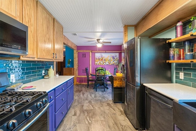 20490 Rocky Branch Rd, Rogers, AR 72756 - kitchen featuring appliances with stainless steel finishes, decorative backsplash, light countertops, ceiling fan, and blue cabinets