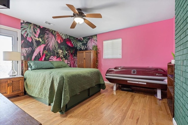 20490 Rocky Branch Rd, Rogers, AR 72756 - bedroom with an accent wall, wallpapered walls, wood finished floors, and a ceiling fan