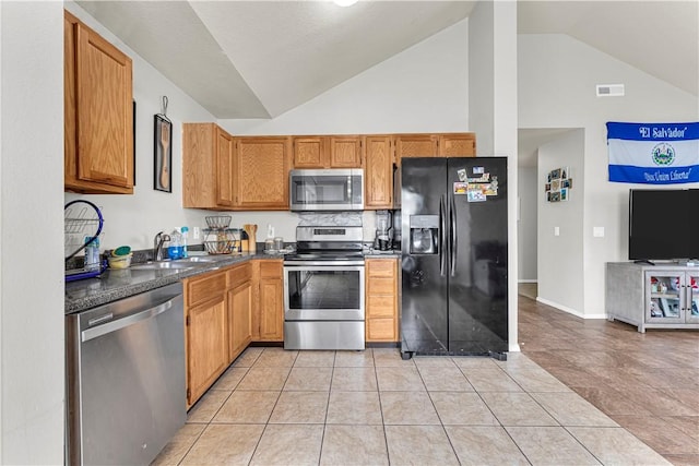 389 Cascade Cir, Springdale, AR 72764 - kitchen with appliances with stainless steel finishes, dark countertops, light tile patterned floors, high vaulted ceiling, and brown cabinetry