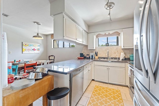 16841 Heritage Bay Rd Unit E-4, Rogers, AR 72756 - kitchen with appliances with stainless steel finishes, backsplash, a peninsula, and white cabinetry